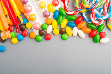Colorful candies over grey paper background