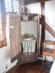old wooden wash cupboard basin sink closet in corner of english manor house room antique