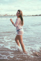 Fototapeta na wymiar Beautiful young woman on the beach at sunset