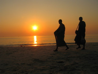 Monjes budistas al atradecer en playa de Ko Samet,isla en la provincia de Rayong, Tailandia, situada en el golfo de Tailandia al sur de Bangkok