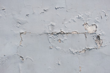 The texture of the cracked wall with the stucco plaster on the brick