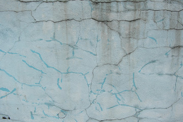 The texture of the cracked wall with the stucco plaster on the brick