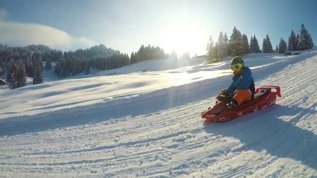 Father and his little son enjoying a sledge ride in famous ski resort in Alps.
