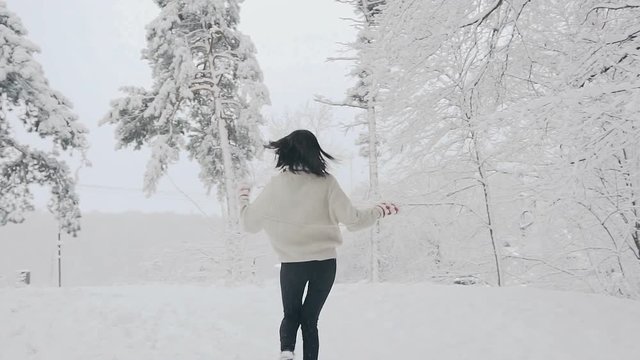 A young woman walks in a snow-covered forest. Frosty winter day. Christmas holidays. Winter