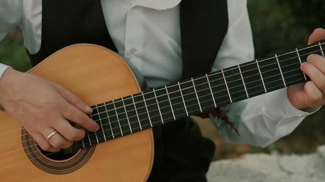 Man playing guitar close up outdoors. Slow motion
