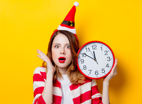 Woman in Santa Claus hat with clock