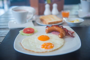 fried egg with ham and sausage on dish