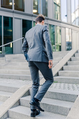 businessman walking upstairs in an office park