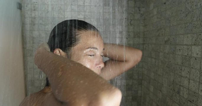 Shower Woman, Young woman showering washing in hair in hot water in luxury bathroom. Happy adult relaxing enjoying luxury bathtime cleaning her face and rinsing her body at home. Mixed race model.