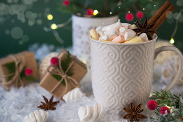 Fototapeta na wymiar Hot chocolate in a white cup with marshmallows and Christmas gifts on the bright light background. Christmas drink.