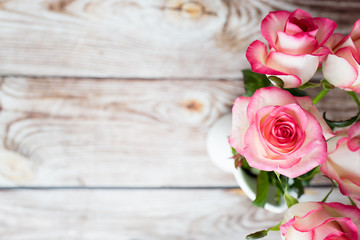 Pink roses on wooden background with empty space for text