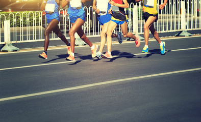 female and male marathon runners running on city road