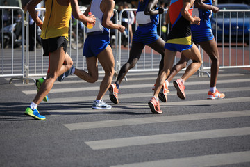 female and male marathon runners running on city road