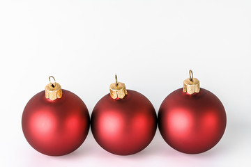 Christmas ornaments isolated on white background. Decoration on card, red shiny baubles with reflections.