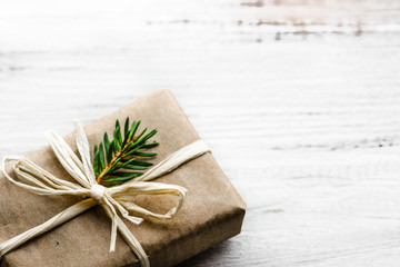 Christmas gift box, present in rustic package with green fir branch on white background