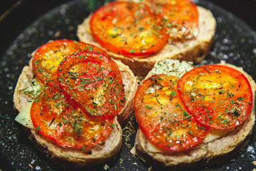 Three bruschettes with tomatoes lie on plate