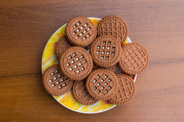 Chocolate cookies with cream filling on wooden table