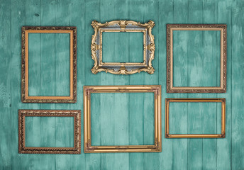 gallery of vintage victorian golden frames isolated on green wooden wall, framework