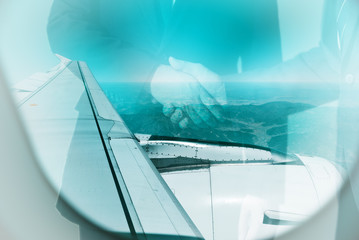 Air traveling and transportation concept. Selective focused on the airplane wing, with businessmen make shake hand in background. Color aquas toned.