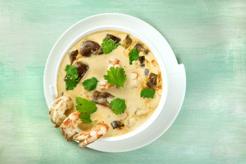 Tom Yam, traditional Thai soup with shrimps and mushrooms, on teal