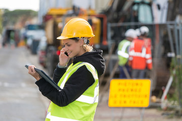 female construction woman using electronics on construction site - 183579979