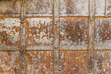 Detail of old metal doors reinforced with steel bands. Weathered cross steel  metallic texture elements of the old door. Antique Background 