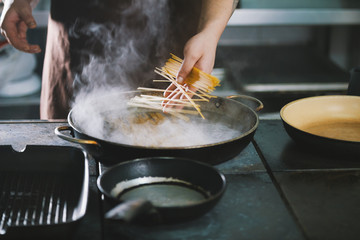 Professional cooking spaghetti in restaurant