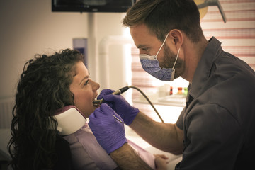 Dentist work with drill on patient.