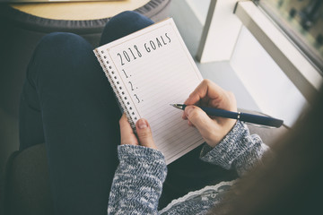 The woman is writing goals for 2018 year
