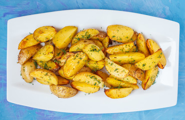 Baked potato slices with herbs in a white dish