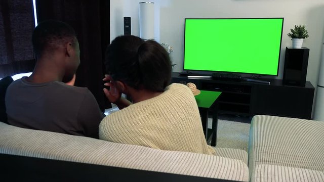 Young black unhappy couple watch television in living room and they are crying 