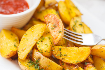 Baked potato slices with herbs in a white dish