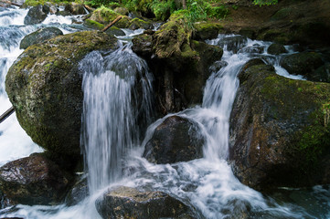 Небольшая горная река, вода, падающая через камни.