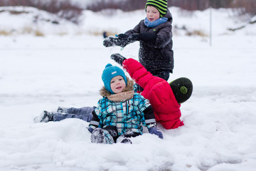 children have fun and play in the snow in the winter
