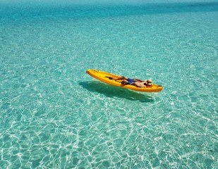 A man sleeping on kayak. Floating in the beautiful sea.