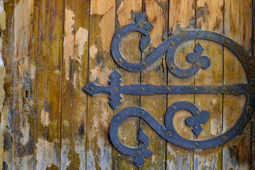 Porte en bois ancienne avec décoration en fer forgé.