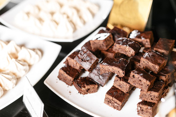 Chocolate brownies closeup on a black table.