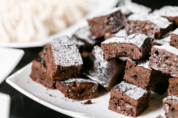 Chocolate brownies closeup on a black table.