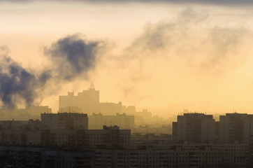Fototapeta na wymiar Smoke from industrial chimneys at dawn city.
