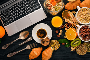 Business breakfast, muesli, coffee, milk, fruits, nuts and seeds, on a wooden surface. Top view. Free space for text.