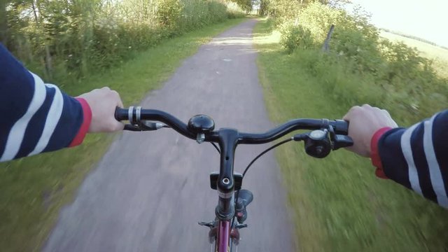 Riding bike on rural road, pov action film clip in fast motion. Adventure and sports in nature. 