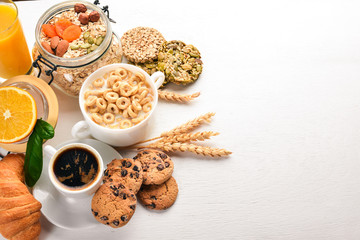 A healthy breakfast. Orange juice, kiwi, croissants, cookies, coffee, on a wooden surface. Top view. Free space for text.