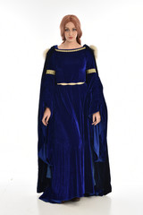 full length portrait of girl wearing long blue velvet gown and fur lined cloak, standing pose  on...