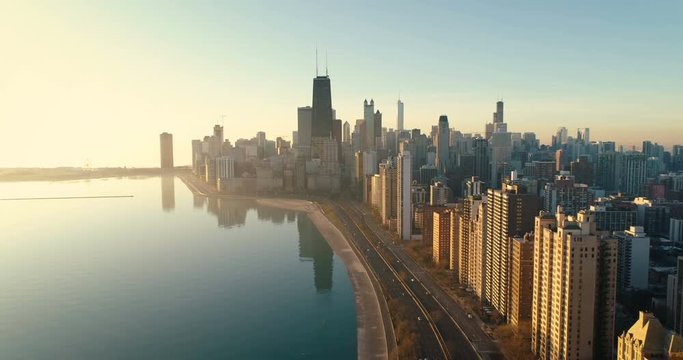 Aerial shot of Chicago Downtown skyline at sunrise. Buildings by the lake shore with road and cars