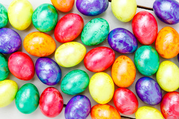 Fototapeta na wymiar Easter eggs on wooden background. Colorful eggs in different colors - red, yellow, orange, purple and green.