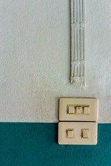 White lighting switch on concrete wall, on and off