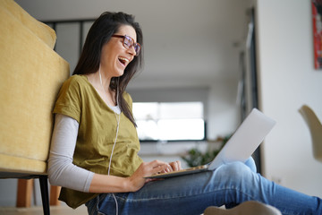 Trendy woman relaxing at home connected with laptop