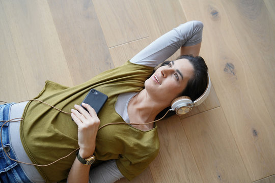 Woman listening to music with smartphone and headphones