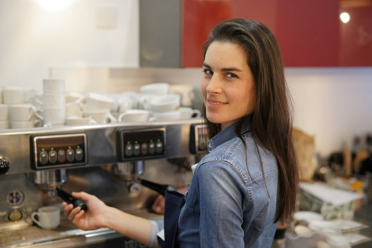 Waitress serving expresso from coffee machine