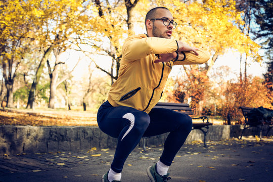 Man doing Squats at public park. On the move.